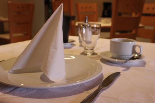 a table with a white plate with a napkin on it at PONI NAKLO - Sobe Marinšek in Naklo