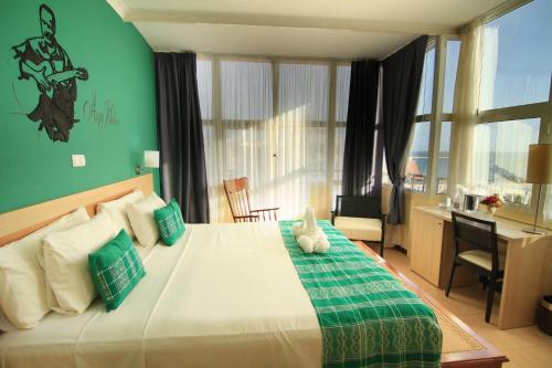 a bedroom with a large bed with a desk and a room at Hotel Santa Maria in Praia
