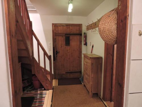a hallway with an open wooden door and stairs at Gregor's Ferienhaus im Wald in Edelschrott