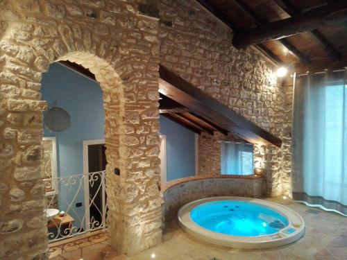 baño grande con bañera de hidromasaje en un edificio de piedra en Dimora & Spa Il Cerchio di Lullo, en Fumone