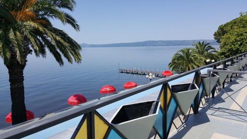 a view of the water with umbrellas on a dock at Hotel Lido - Beach and Palace in Bolsena