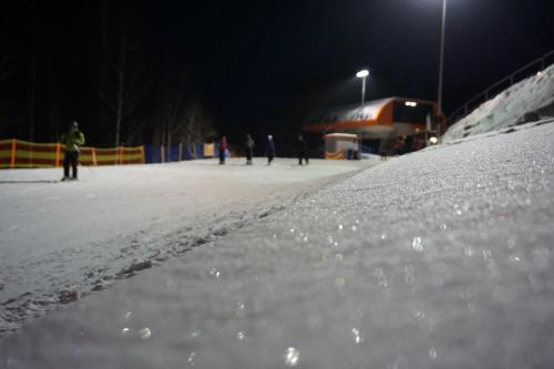a group of people skiing on a snow covered slope at night at Villa Winterpol in Karpacz