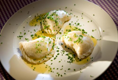 a white plate with dumplings with chives on it at Der Paternwirt in Maria Luggau