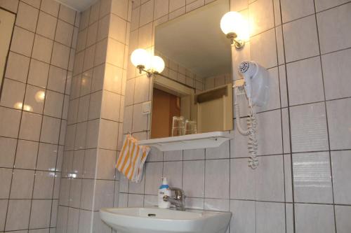 Hotel Am Roonplatz في بون: حمام مع حوض ومرآة