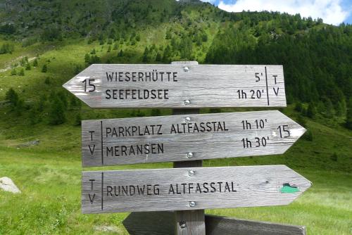 a wooden sign with arrows on a mountain at Pitznerhof in Maranza