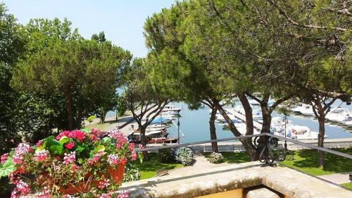 a balcony with flowers and trees and a body of water at Hotel Royal in Bolsena
