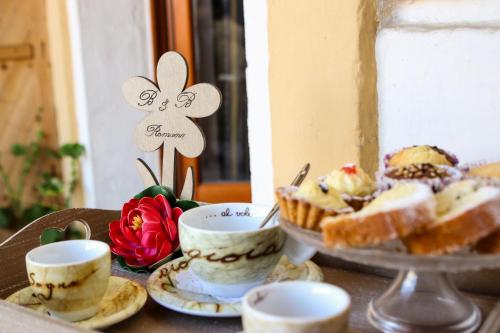 a table topped with cups and cakes and desserts at Romano B&B in San Severo