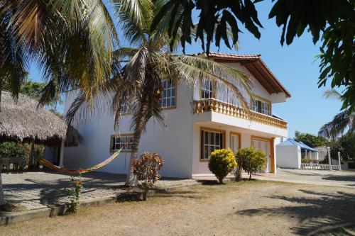 a house with a palm tree in front of it at Condominio Punta Bolivar in San Antero