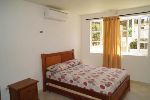 Schlafzimmer mit einem Bett und einem Fenster in der Unterkunft Condominio Punta Bolivar in San Antero