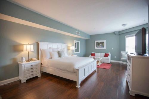 a bedroom with a white bed and a television at Oakwood Resort in Syracuse
