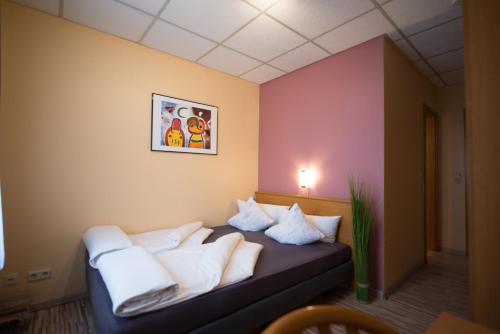 a room with a bed with white pillows at Rheinauer Hof - bed & breakfast in Mannheim