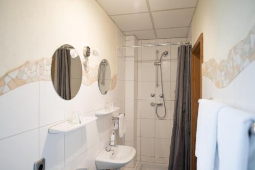 a bathroom with two sinks and a shower at Rheinauer Hof - bed & breakfast in Mannheim