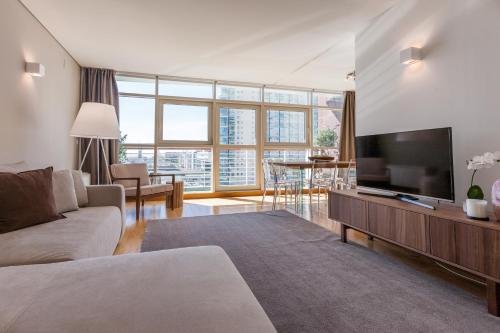 a living room with a couch and a flat screen tv at Your Lisbon Home Oriente in Lisbon