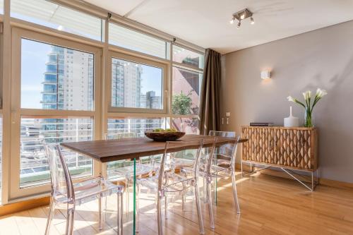a dining room with a table and chairs and a large window at Your Lisbon Home Oriente in Lisbon