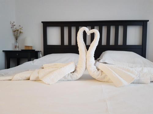 two swans made out of towels sitting on a bed at Pensiunea Agroturistica Cerna, Vaideeni - Polovragi in Vaideeni