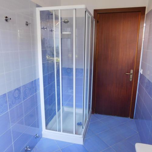 a shower with a glass door in a bathroom at Villa Cà D'Oro in Duna Verde