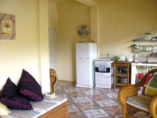 a living room with a white refrigerator and a stove at Lillibets in Castara