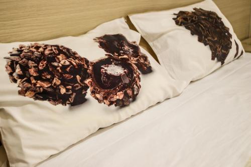 Due ciambelle ricoperte di cioccolato sedute sopra un letto di Romano B&B a San Severo
