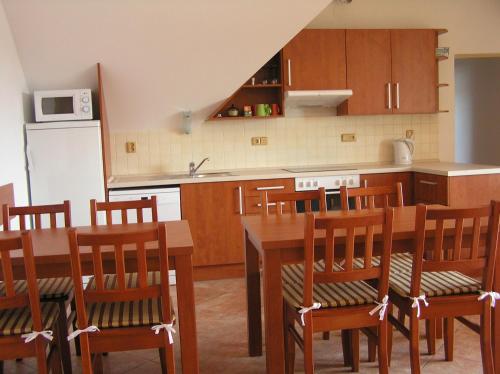 a kitchen with a table and chairs and a refrigerator at Penzion U Tomášů in Wschechowitz