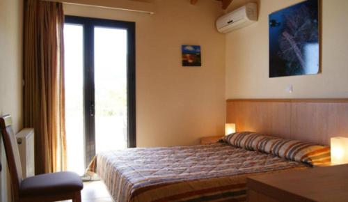 a bedroom with a bed and a large window at Angela's House Hotel in Monemvasia
