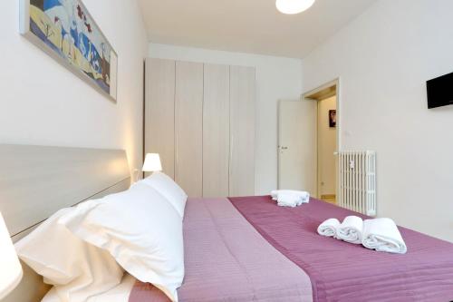 ローマにあるComfort Suite Mariniana close to the Vaticanのベッドルーム1室(紫色のベッド1台、タオル付)