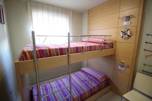 two bunk beds in a room with a window at Mirador al Mar 12 in Denia