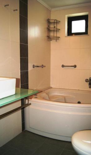 a bathroom with a tub and a toilet and a sink at Angela's House in Monemvasia