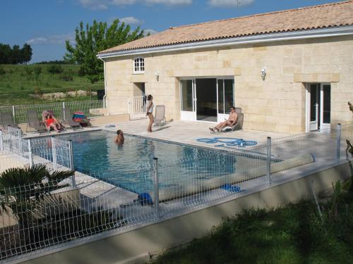 un gruppo di persone sedute in piscina di Gite Le Chardon Fleuri a Teuillac