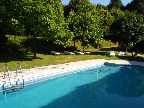 una gran piscina azul con sillas y árboles en Casa San Ginés, en Cruces