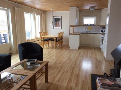 a living room and kitchen with a table and chairs at Siljan Utsikt Semesterhus in Sjurberg