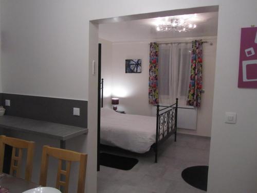a bedroom with a bed and a table and a desk at Residence Alassa in Montévrain