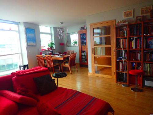 a living room with a red couch and a dining room table at LxRiverside Suite Apartment in Lisbon