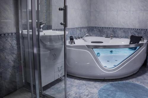 a bathroom with a bath tub and a sink at King Hotel in Peje