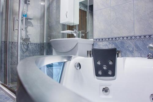 a bathroom with a white tub and a sink at King Hotel in Peje