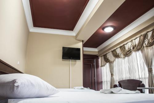 a bedroom with a bed and a tv on the wall at King Hotel in Peje