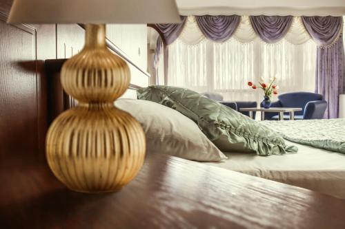 a bedroom with a bed with a lamp on it at King Hotel in Peje