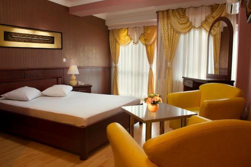 pokój hotelowy z łóżkiem, stołem i krzesłami w obiekcie King Hotel w mieście Peć
