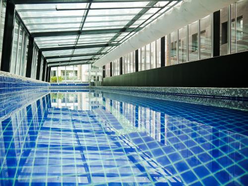 a swimming pool with blue tiles in a building at Museum Apartment Hotel, Independent Collection by EVT in Wellington