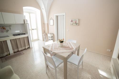 モットラにあるLa dimora di Mariaのダイニングルーム(テーブル、白い椅子付)