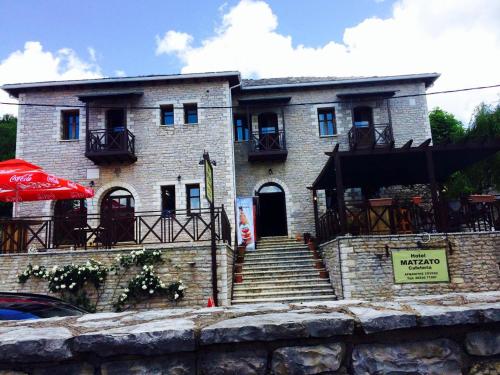 a large brick building with stairs in front of it at Matzato in Monodendri