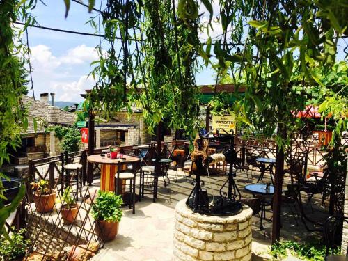an outdoor patio with tables and chairs and trees at Matzato in Monodendri