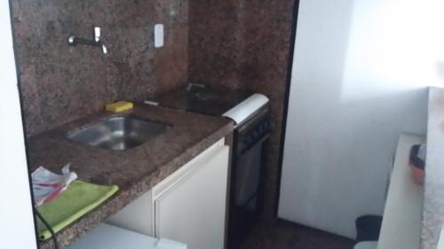 una pequeña cocina con fregadero y lavavajillas en Atlantico Residence Beira Mar, en Fortaleza