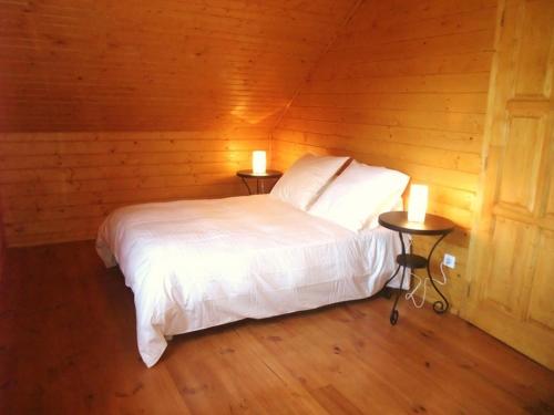 a bedroom with a white bed and two tables with candles at Le Chalet du Berger in Briançonnet