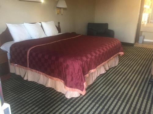a hotel room with a bed with a red blanket at America's Best Inn & Suites Eureka in Eureka
