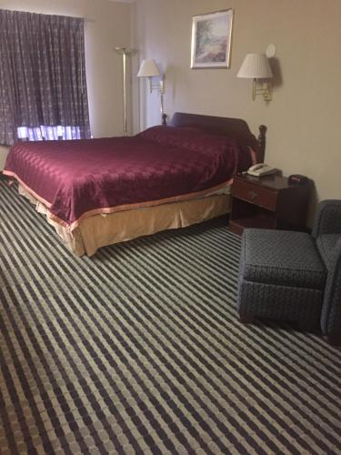 a hotel room with a bed and a chair at America's Best Inn & Suites Eureka in Eureka