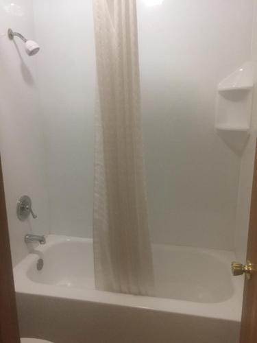 a bathroom with a shower curtain and a bath tub at America's Best Inn & Suites Eureka in Eureka