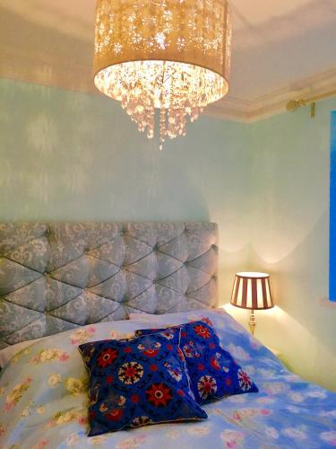 a bedroom with a bed and a chandelier at Angel's (station accommodation) in Cambridge