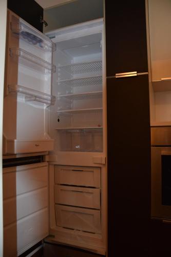 - un réfrigérateur vide avec une porte ouverte dans la cuisine dans l'établissement Casa Nostra, à Bellagio