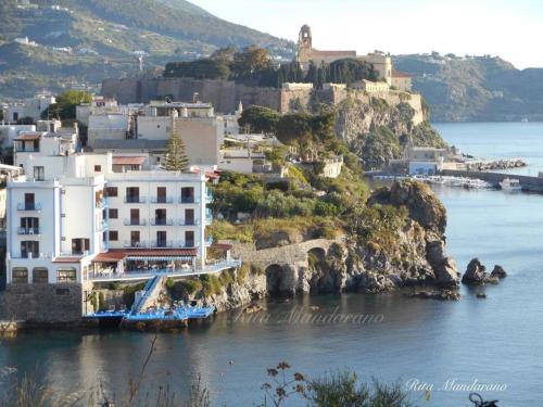 a building on a hill next to the water at Casa vacanze Lipari da Sergio spiaggia sotto casa in Lipari