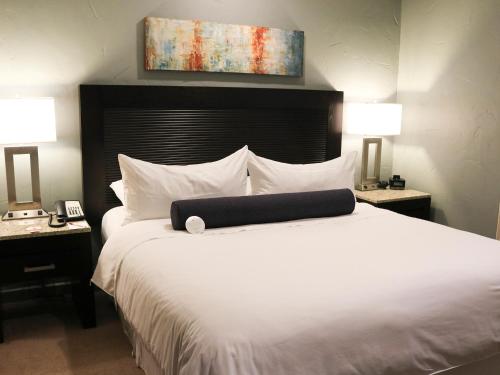 um quarto com uma grande cama branca e 2 candeeiros em Hotel Coral & Marina em Ensenada